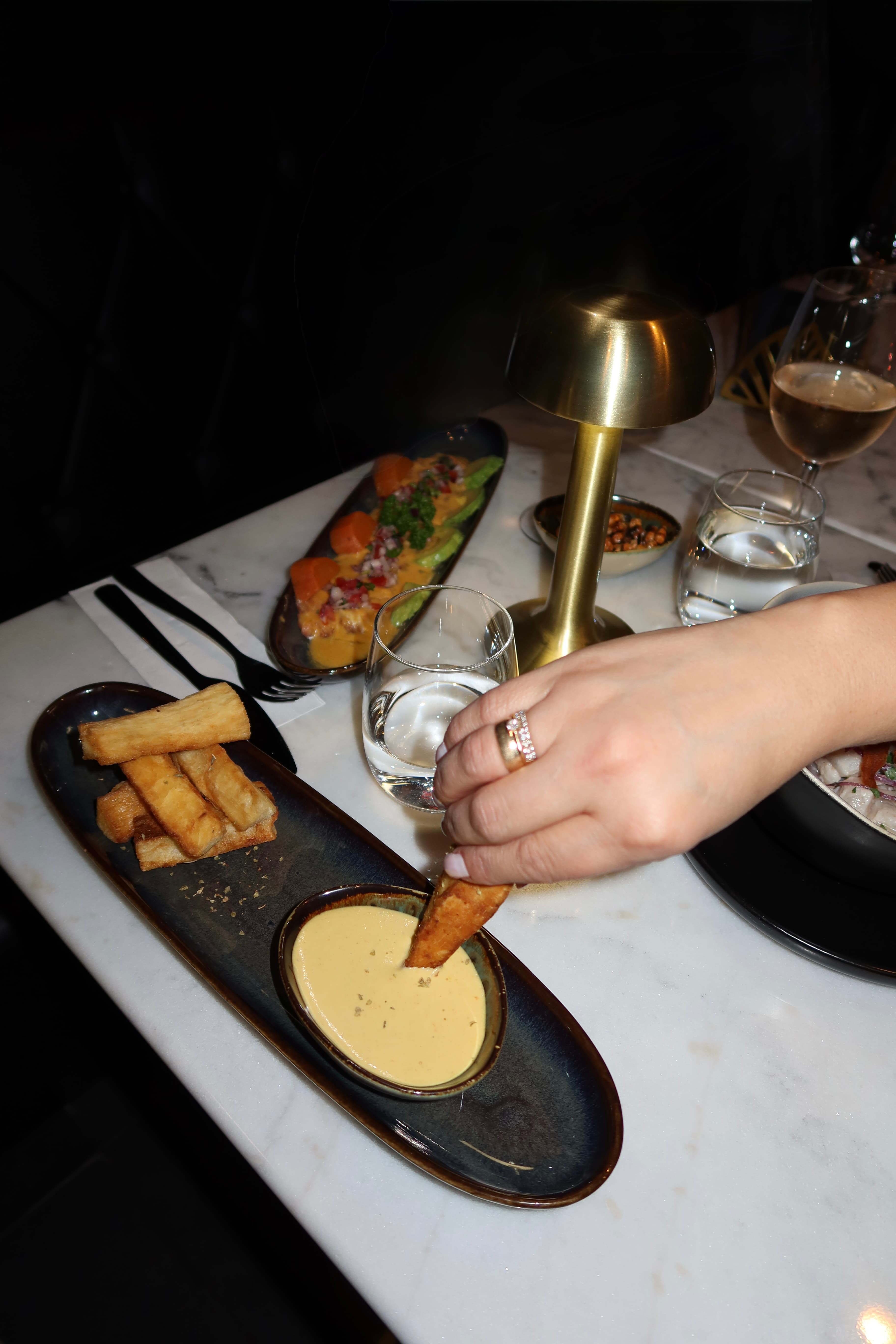 Yuca fries and dipping sauce to share on a marble table