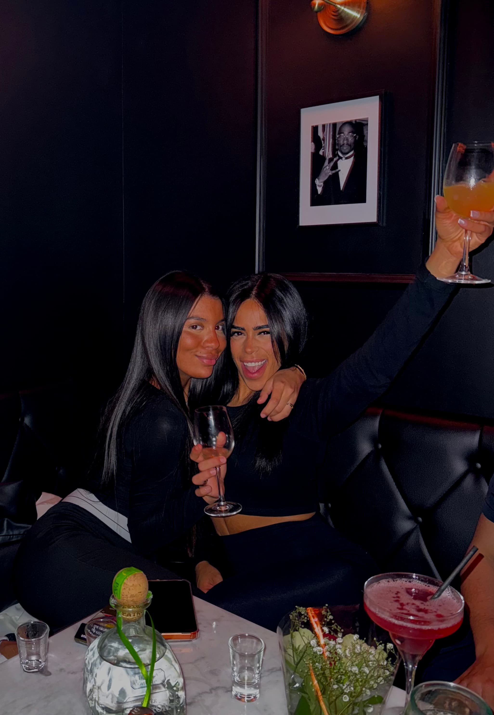 Guests toasting cocktails in the dimly lit bar interior